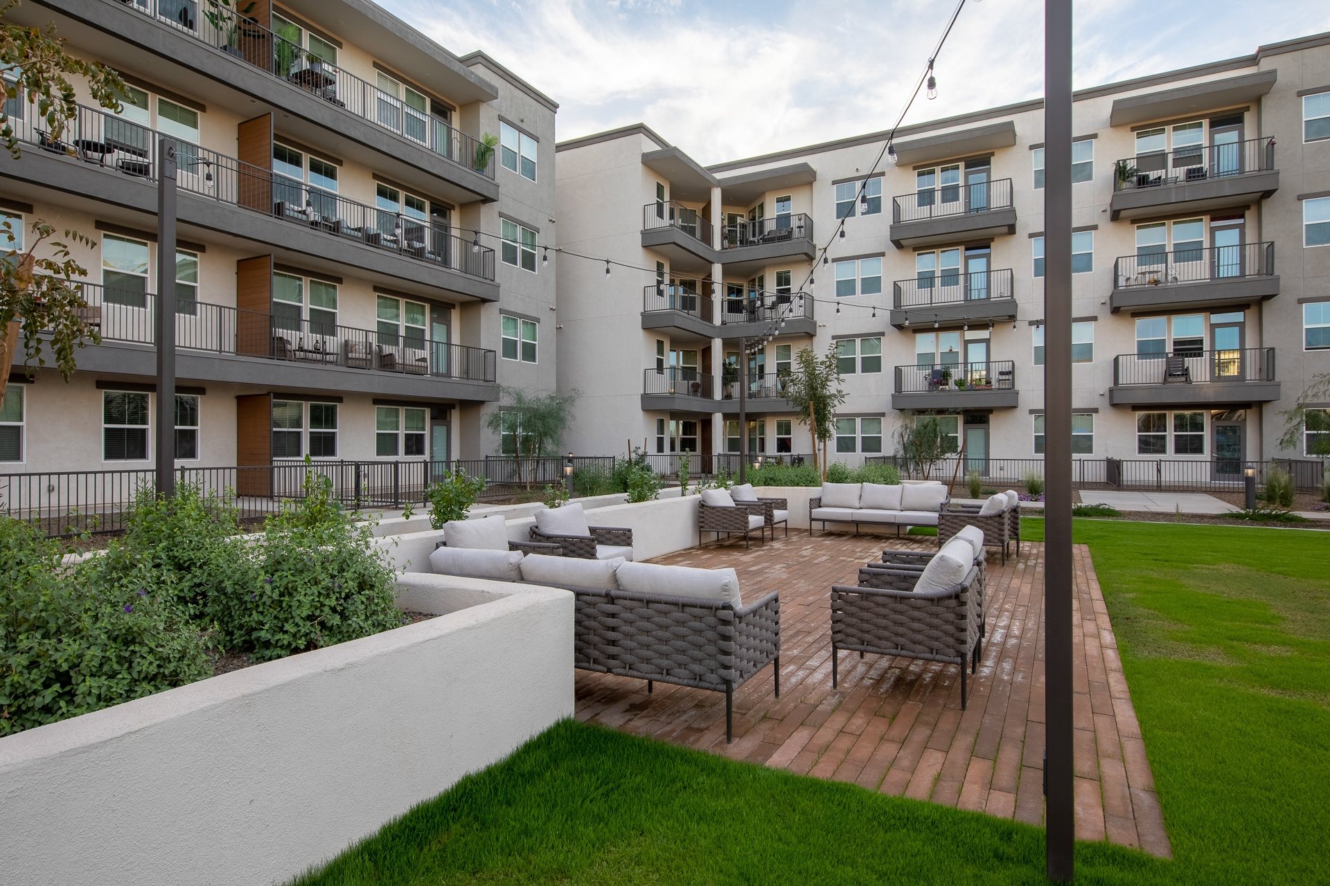a brick patio with multiple lounge seating areas at a senior apartment community